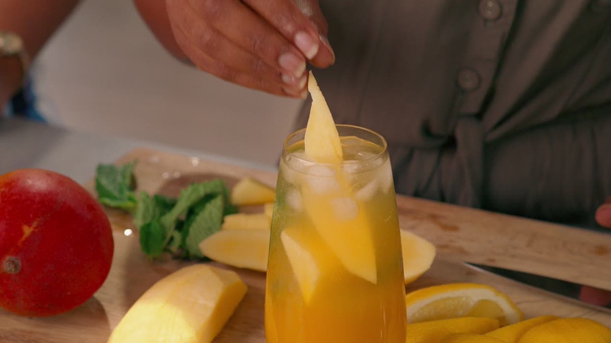 A mango cocktail being garnished