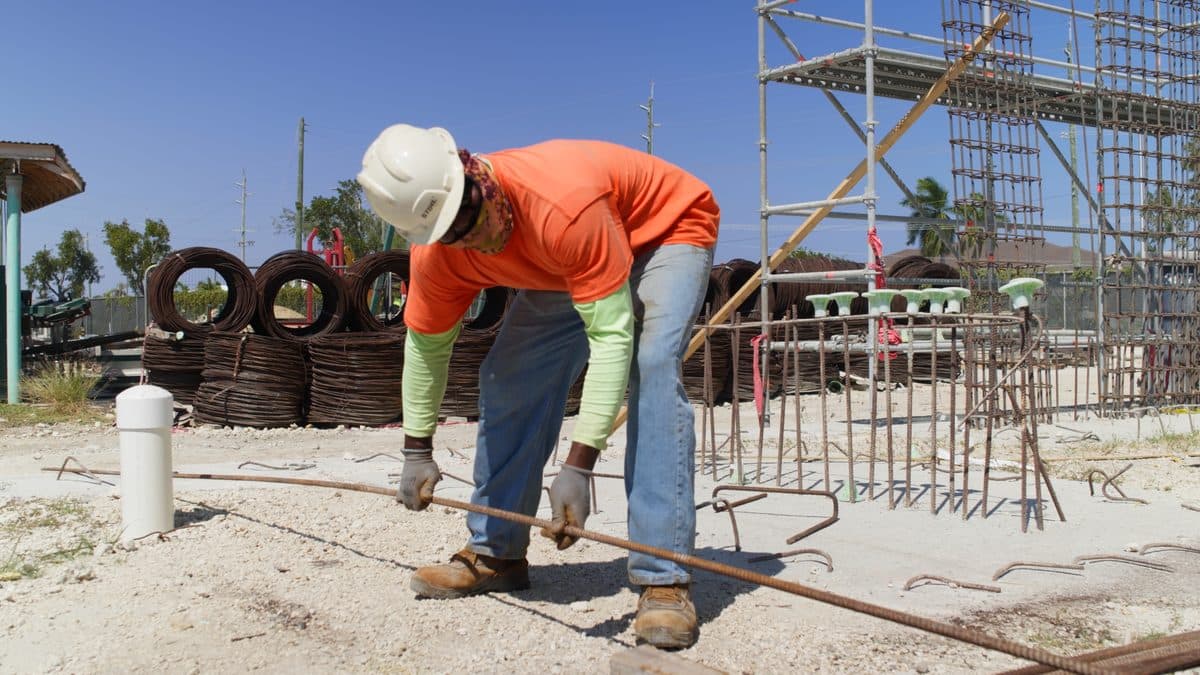 A worker on a construction site in hard midday sun
