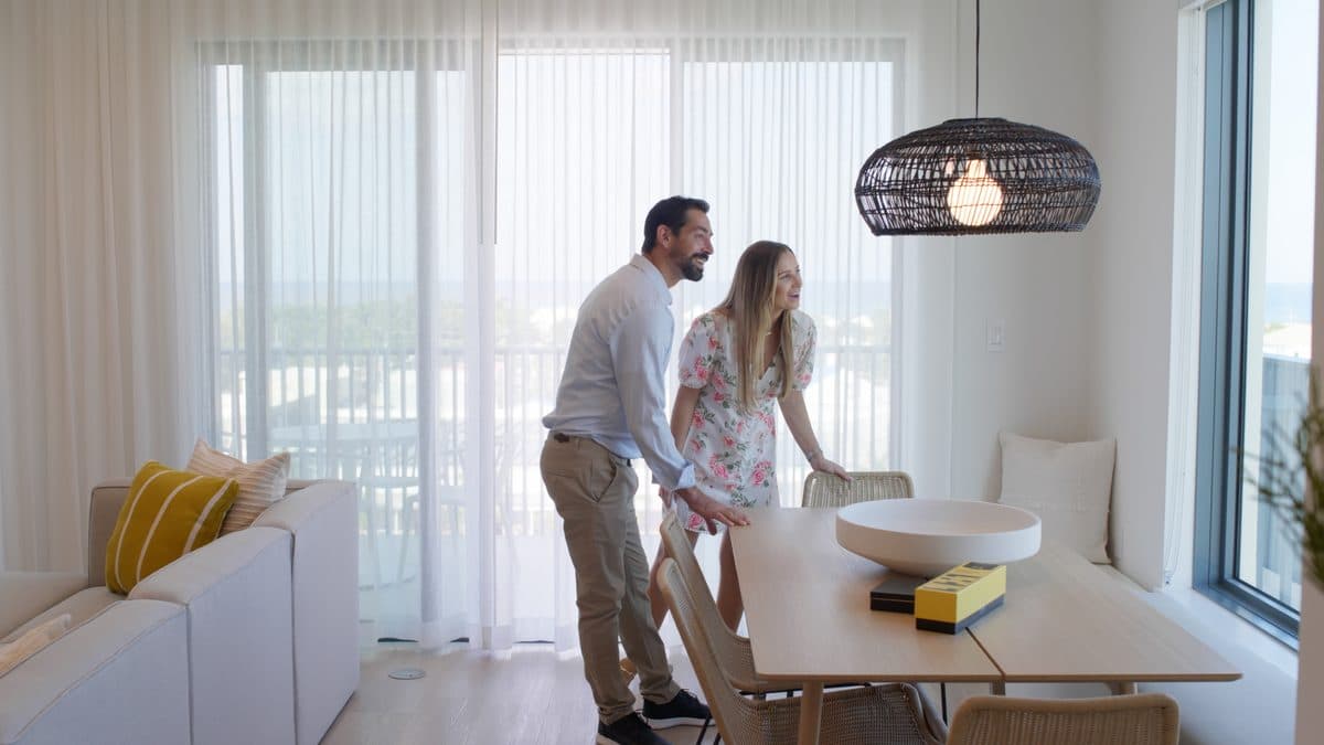 A couple in a residence lit entirely by its windows